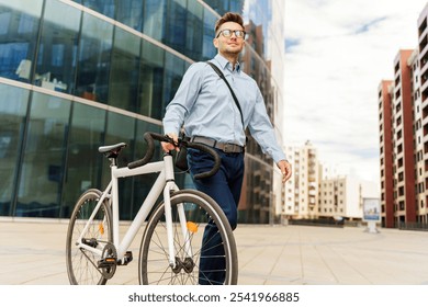 Young Man Walking With a Bicycle Near Modern Buildings in a Bustling Urban Area on a Sunny Day - Powered by Shutterstock