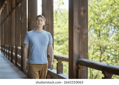 A young man walking down a corridor in a traditional building