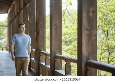 A young man walking down a corridor in a traditional building