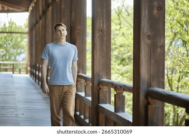 A young man walking down a corridor in a traditional building