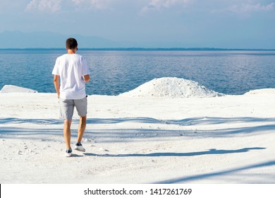 Young Man Walking At Marble Beach The Famous Place On Island Thassos In Nothern Greece. The Only Snow White Marble In Europe. Unique Place Concept