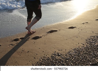 Young Man Walking On The Beach 