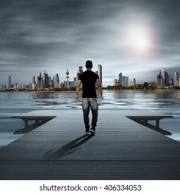 A Young Man Walking On A  Wooden Bridge, Kuwait City Background