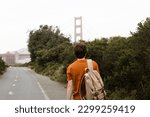 Young man walking in the Presidio National Park with a great view of the Golden Gate Bridge in San Francisco, California