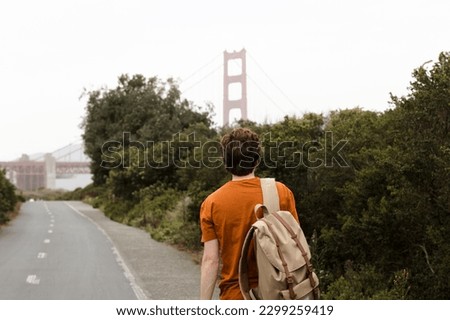 Young man walking in the Presidio National Park with a great view of the Golden Gate Bridge in San Francisco, California