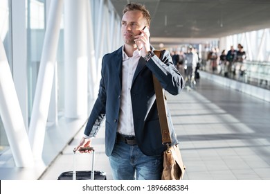 Young Man Walking Through Airport Gate And Talking On Phone