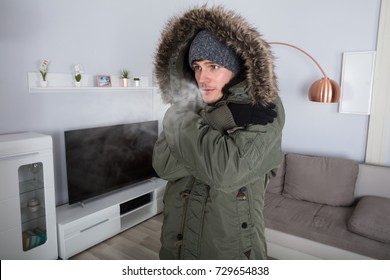 Young Man With Warm Clothing Feeling The Cold Inside House