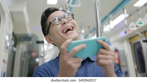 Young Man Watch The Video With Phone On The MRT Or Train