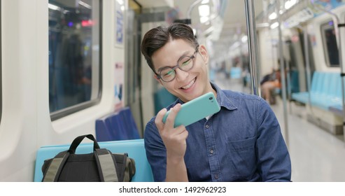 Young Man Watch The Video With Phone On The MRT Or Train