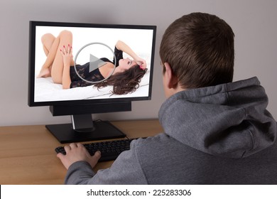 young man watching erotic video on computer at home