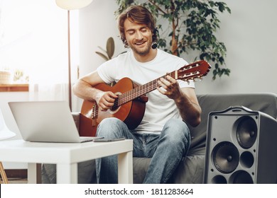 Young Man Watching Guitar Tutorial On His Laptop