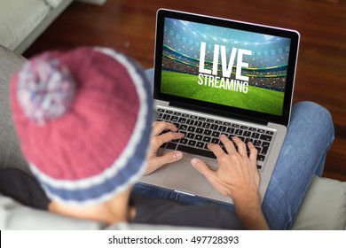 Young man watching live streaming sports event. All screen graphics are made up.