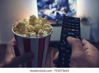 young man Watching a Movie in his living room with popcorn and remote control, Point of view shot