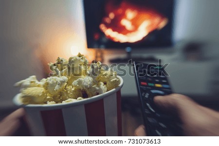 young man watching a movie with popcorn and remote controller, Point of view shot 