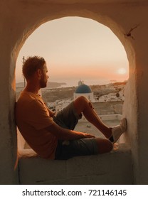 Young Man Watching Sunset At Old Village Pyrgos Can Found At The Highest Point Of Santorini, With Panoramic Views Of The Whole Island All The Way To The Village Of Oia