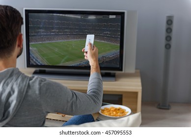 Young Man Watching Television At Home