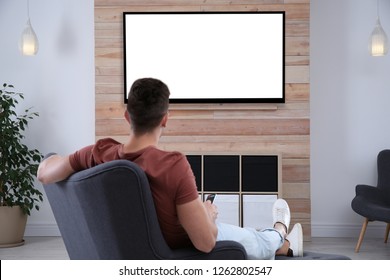 Young Man Watching TV In Armchair At Home. Mockup For Design