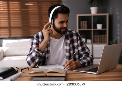 Young Man Watching Webinar At Table In Room