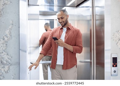 A young man wearing casual attire checks his smartphone while entering an elevator. The scene emphasizes modern technology usage in everyday activities. - Powered by Shutterstock