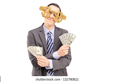 A Young Man Wearing Dollar Sign Glasses And Holding US Dollars Isolated On White Background