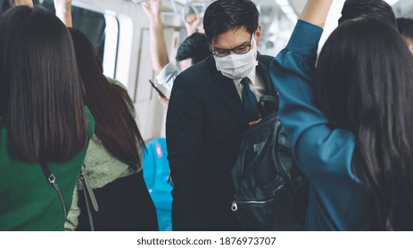 Young Man Wearing Face Mask Travels On Crowded Subway Train . Coronavirus Disease Or COVID 19 Pandemic Outbreak And Urban Lifestyle Problem In Rush Hour Concept .