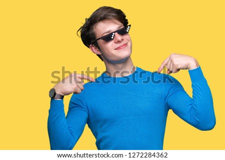 Young man wearing funny thug life glasses over isolated background looking confident with smile on face, pointing oneself with fingers proud and happy.