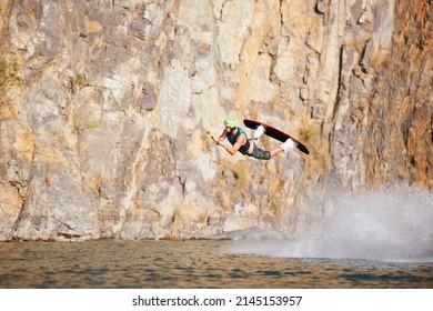 A Young Man Wearing A Helmut And Lifejacket Wakeboarding On A Lake. A Young Man Wearing A Helmet And Lifejacket Wakeboarding On A Lake.