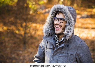 Young man wearing a jacket with a hood in a cold autumn day