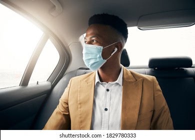 Young Man Wearing Mask In Back Of Taxi During Health Pandemic Going Out On Date