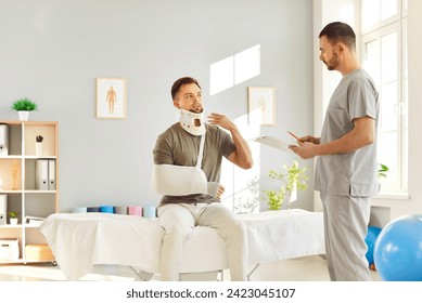 Young man wearing neck collar and arm sling sitting on medical bed at clinic and talking to his doctor. Neck injury, broken arm, trauma treatment concept - Powered by Shutterstock