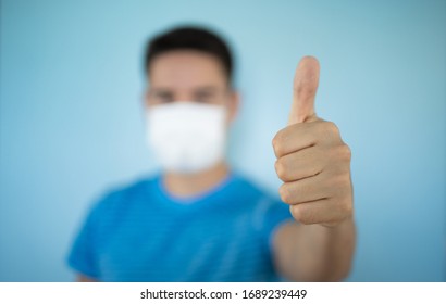 Young Man Wearing A Protective Mask With Thumbs Up. Help Stop The Spread Of Coronavirus Concept. 