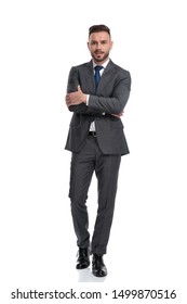 Young Man Wearing Suit And Tie Stands With Hands Crossed, Isolated On White Background