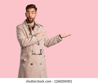 Young Man Wearing Trench Coat Holding Something With Hand