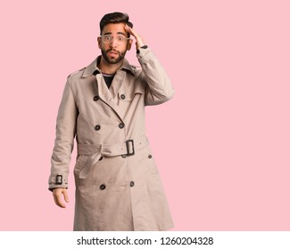 Young Man Wearing Trench Coat Worried And Overwhelmed