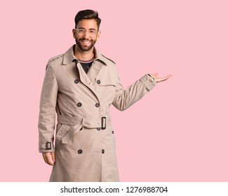 Young Man Wearing Trench Coat Holding Something With Hand