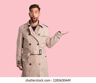 Young Man Wearing Trench Coat Holding Something On Palm Hand