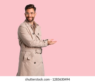 Young Man Wearing Trench Coat Holding Something With Hands