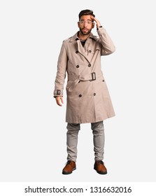 Young Man Wearing Trench Coat Worried And Overwhelmed