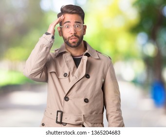 Young Man Wearing Trench Coat Worried And Overwhelmed