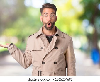 Young Man Wearing Trench Coat Holding Something On Palm Hand