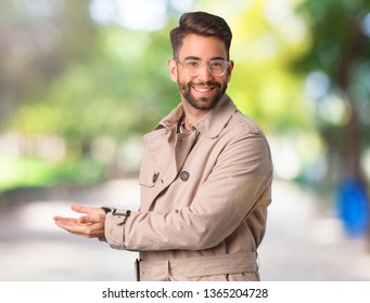 Young Man Wearing Trench Coat Holding Something With Hands