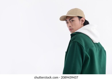 Young Man Wearing A White Hoodie With Green Shirt With Hat In Studio

