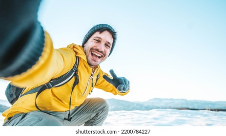 Young man wearing winter clothes taking selfie picture in winter snow mountain - Happy guy with backpack hiking outside - Recreation, sport and people concept - Shutterstock ID 2200784227