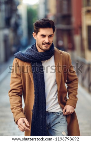 Young man wearing winter clothes in the street.