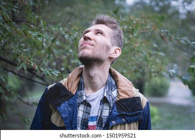 Young Man In Wet Clothes Under Pouring Strong Stormy Rain