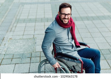 Young Man In The Wheelchair Going Outside And Smiling