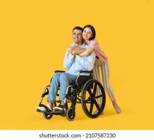 Young man in wheelchair and his wife on color background - Powered by Shutterstock