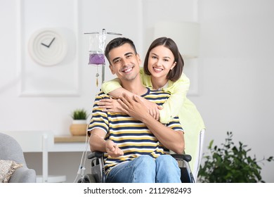 Young Man In Wheelchair On IV And His Wife At Home