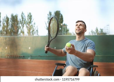 Young Man In Wheelchair Playing Tennis On Court