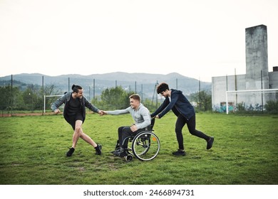 Young man in wheelchair spending free time outdoor with friends, having fun in city. Male friendship. - Powered by Shutterstock